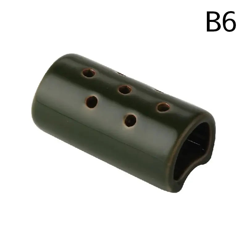Dark green ceramic flute with six circular holes complementing the lotus seedpod ceramic vase in stone sand finish