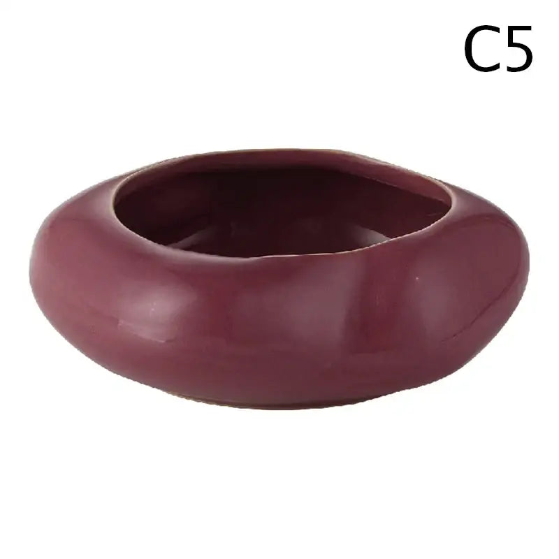 A smooth glossy maroon ceramic vase with rounded edges from the decorbites lotus seedpod stone sand set