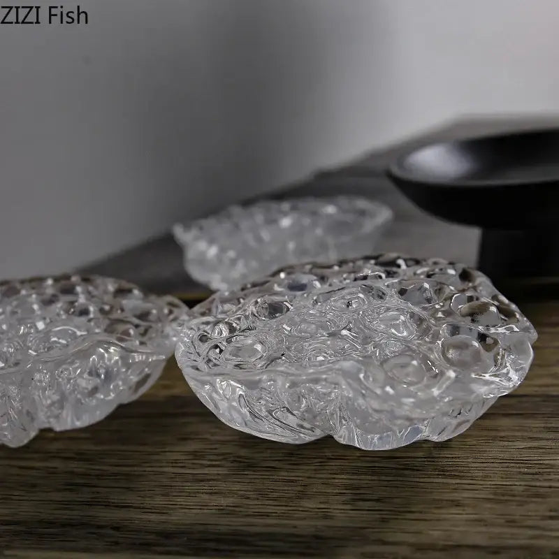 Clear glass coasters shaped like lotus leaves featuring intricate texture in decorbites lotus seedpod resin sculpture design