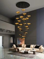 Golden flower-shaped pendant chandelier with sleek black circular ceiling mount from decorbites lotus staircase series