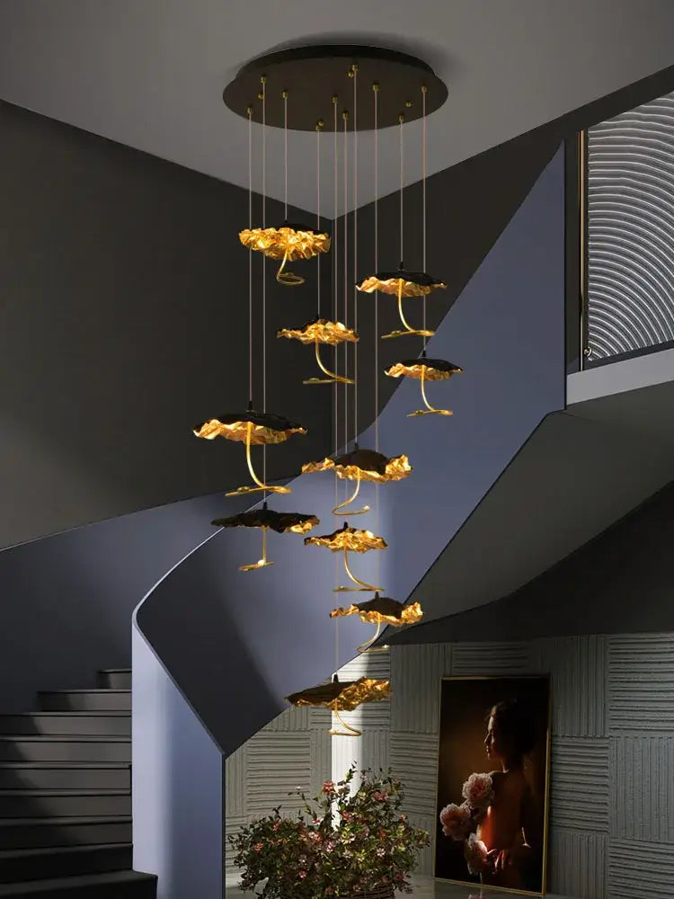 Golden lotus-shaped decorbites lotus staircase LED chandelier with black accents hanging from circular copper mount