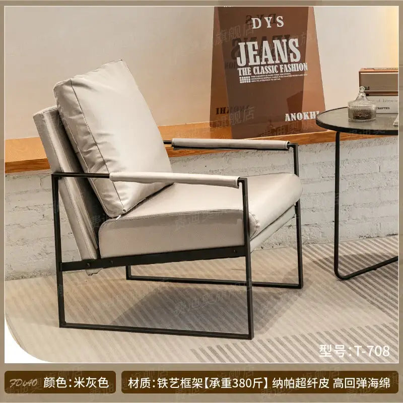 A sleek decorbites lounge chair with black metal frame and light gray faux leather for casual comfort in various spaces