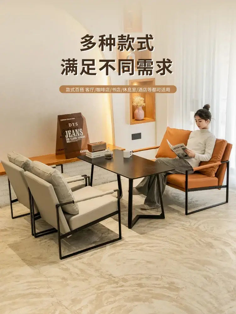 Modern minimalist coffee table with sleek black metal frame and dark wood top complementing single sofa chair designs