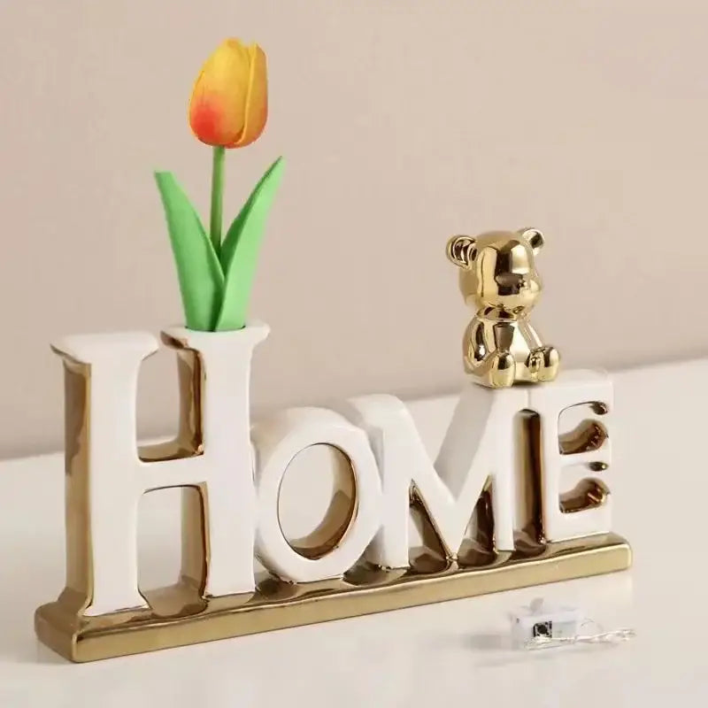 White and gold ceramic home letter set with a yellow-orange tulip and a golden bear figurine from decorbites love bear 3d ceramic collection