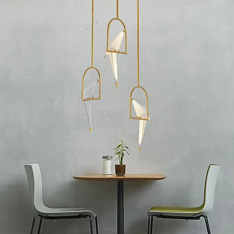 Three gold-toned decorbites love bird chandelier pendant lights with white paper crane shades for dining room