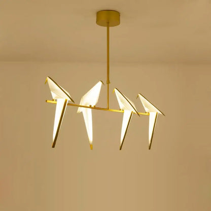 Gold-toned decorbites love bird chandelier lighting with four illuminated origami-style birds on a horizontal bar