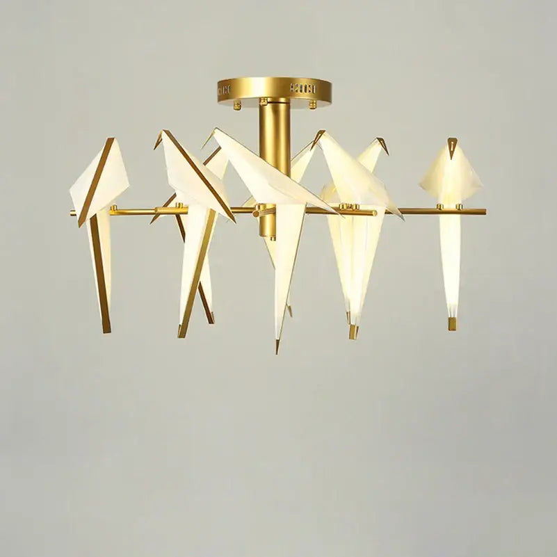 Gold-toned decorbites love bird chandelier with origami-style white paper birds and illuminated interiors for dining room