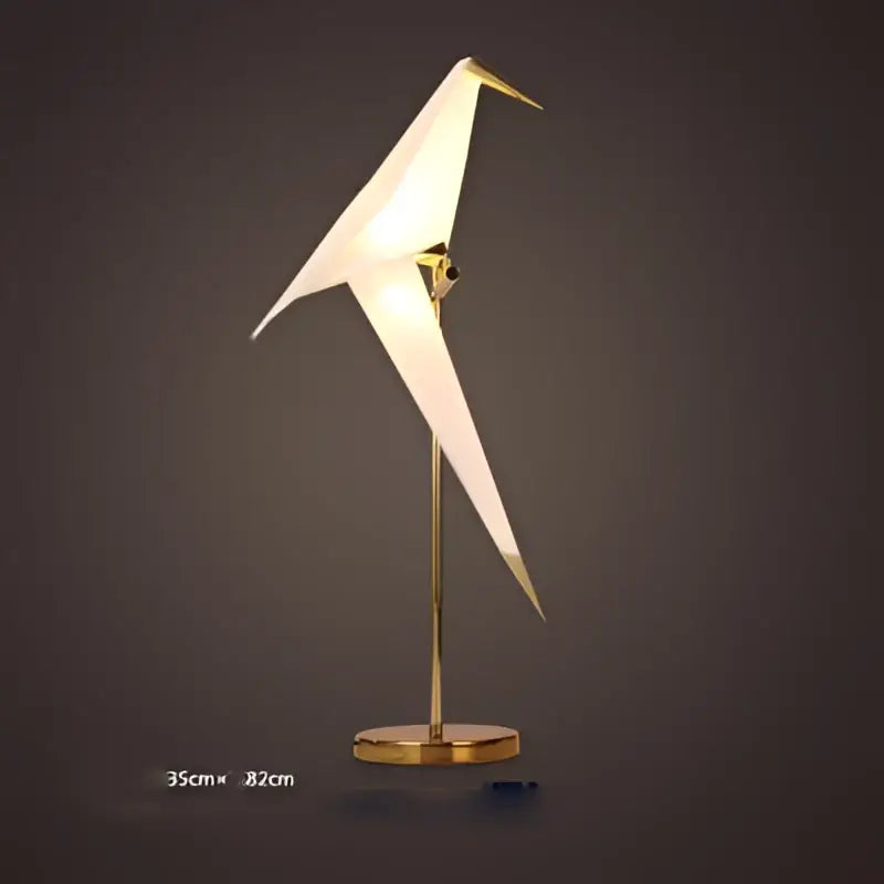 A decorbites love bird chandelier featuring a white translucent origami bird lamp with a gold metal frame for dining rooms