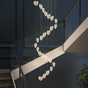 A modern decorbites love chandelier with white heart-shaped crystal lights in a cascading gold design for living room