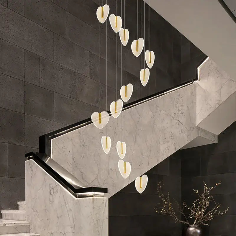 A modern heart-shaped pendant light with white acrylic and gold accents by decorbites love chandelier for luxury spaces