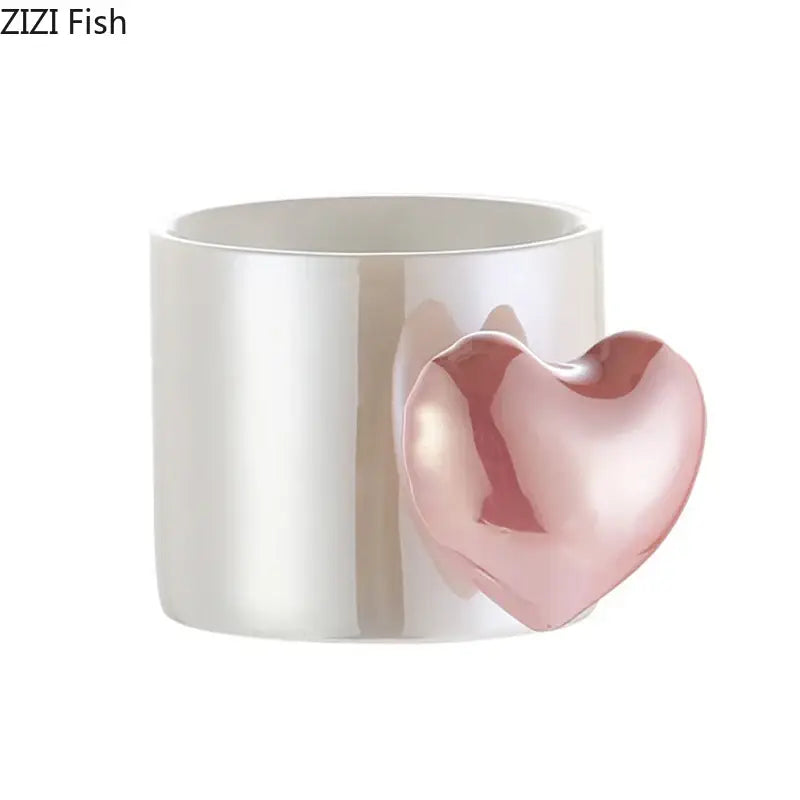 A glossy white ceramic mug with a blush pink love heart ceramic handle for coffee tea or juice by DecorBites™