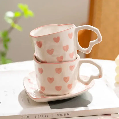 A pair of white ceramic DecorBites love heart hand painted coffee mugs with pink hearts and heart-shaped handles
