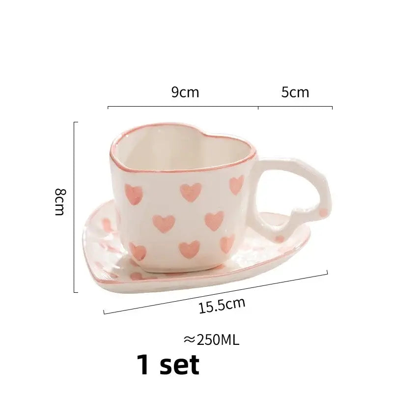 A white ceramic coffee cup and saucer set with pink decorbites love heart hand painted patterns and matching handle design