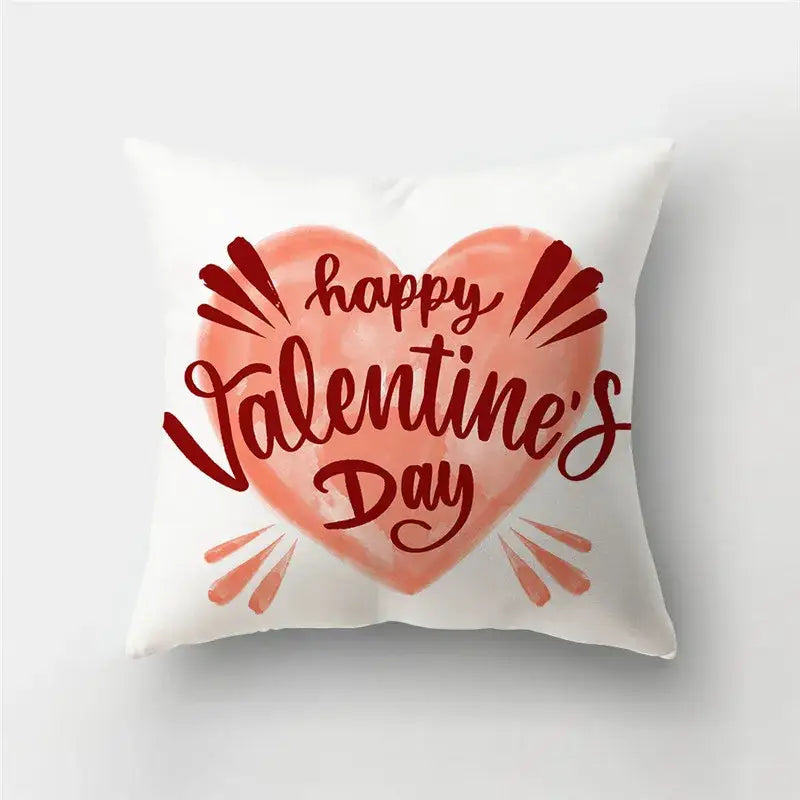 White throw pillow cover with a love heart print featuring a peach heart and happy valentines day in red cursive