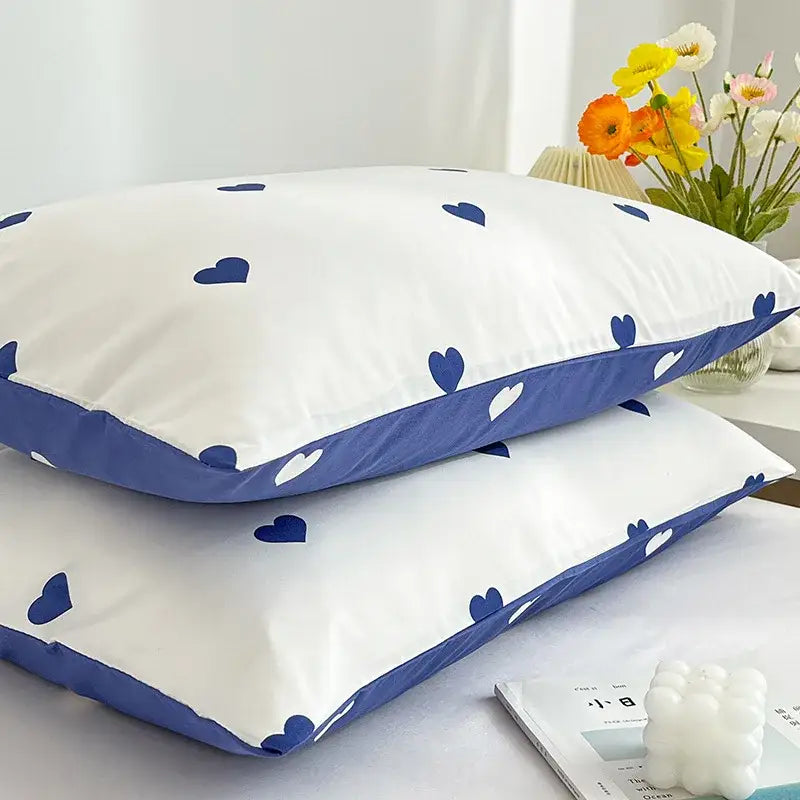 White pillowcases with blue heart patterns and solid blue border from the decorbites love printed pillowcase set