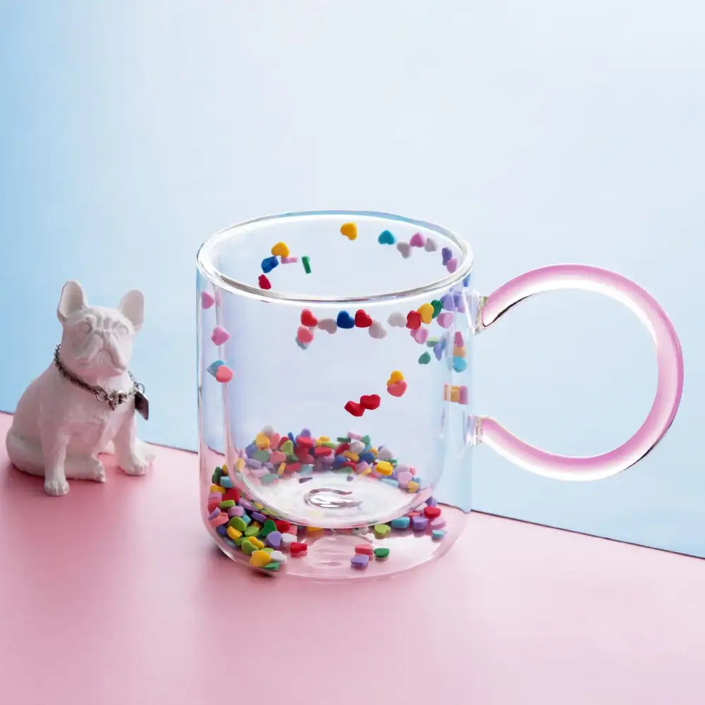 Decorbites love quicksand double bottom glass cup with pink handle containing colorful heart-shaped confetti