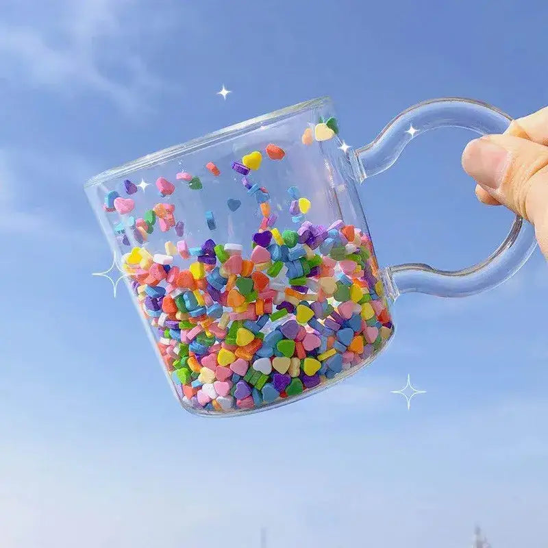 A clear glass cup from decorbites love quicksand featuring colorful heart-shaped confetti in double bottom design