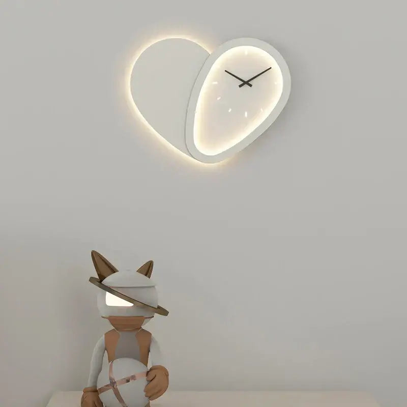A modern decorbites love shaped clock wall lamp with a minimalist white face and dimmable indoor bedroom lighting