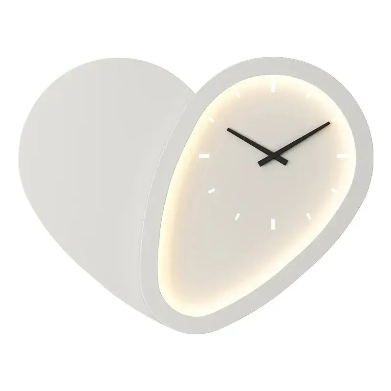 A modern white decorbites love shaped wall lamp with a softly glowing face and minimalist black hands clock