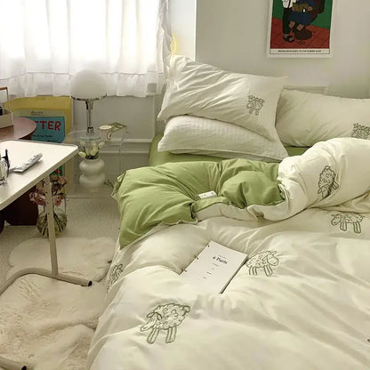 White DecorBites™ bedding set with sheep embroidered design in sage green and cream featuring quilted texture