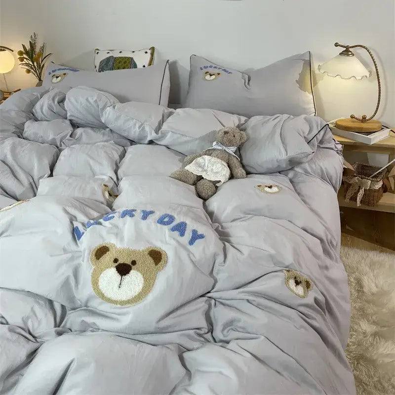 Light gray plush quilt bedding set featuring embroidered bear face happy day text and smaller bear appliqués decorbites sheep embroidered bedding