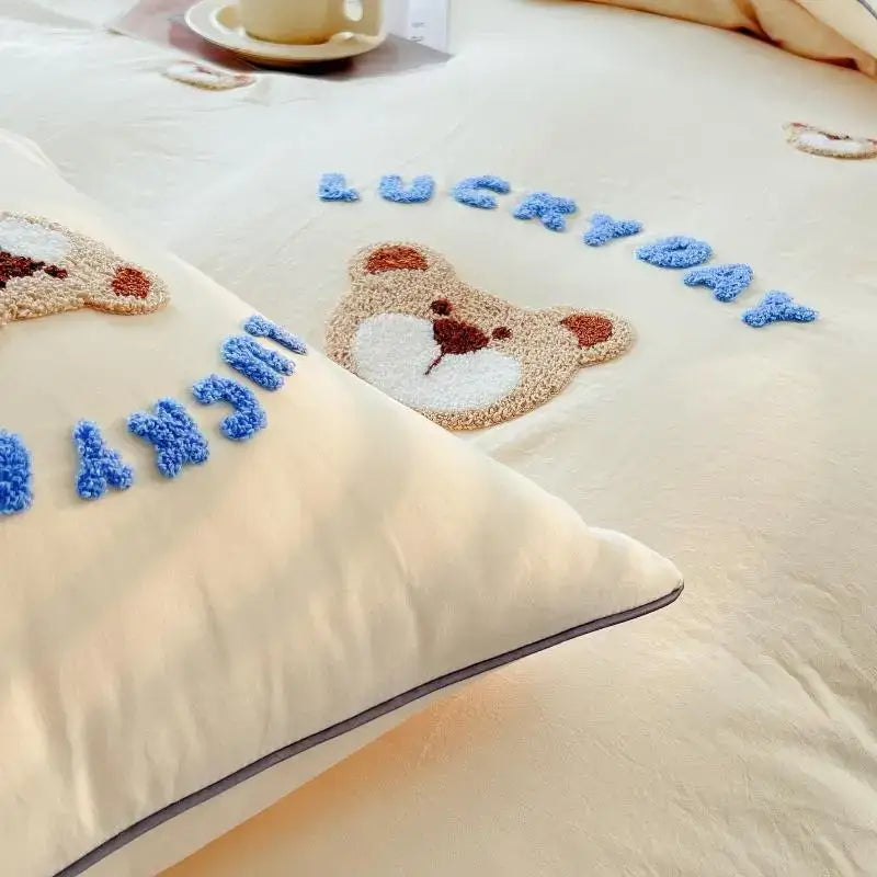 Cream-colored pillow from decorbites lovely bear and sheep embroidered bedding set featuring teddy bear and blue yarn lettering