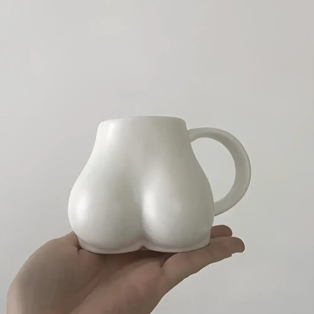 White ceramic coffee cup shaped like buttocks with glossy finish and curved handle from decorbites lovely butt shape collection