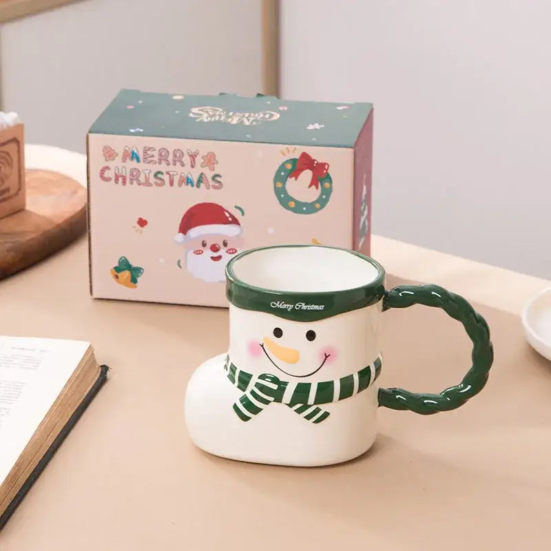 A white ceramic christmas socks ceramic mug shaped like a snowman boot with green accents and a striped scarf design