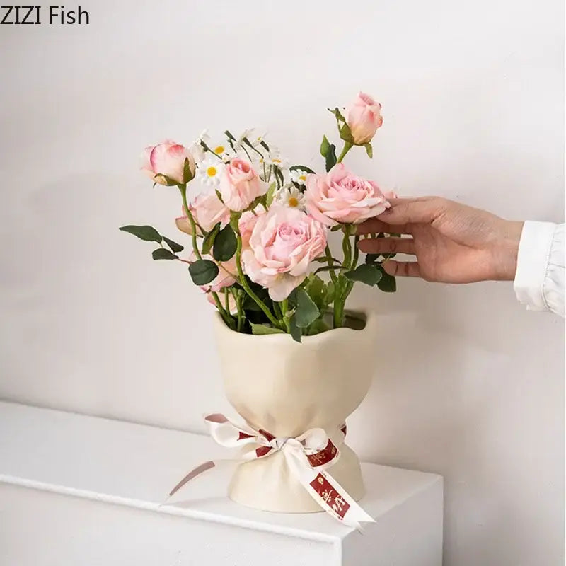 A cream-colored ceramic vase from decorbites lovely ribbon set with a flared top and white ribbon bow with red accents