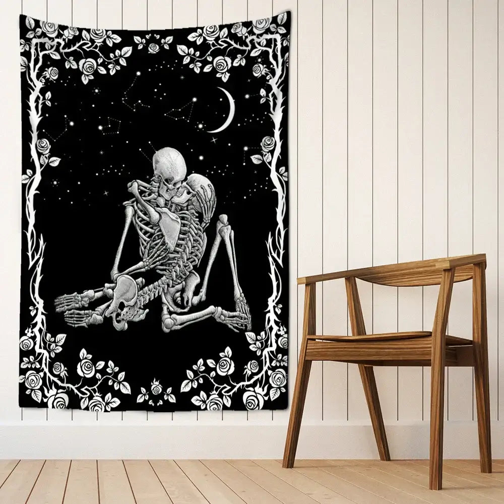 Black and white decorbites lovers skull tapestry wall hanging featuring two embracing skeletons under crescent moon with rose vines