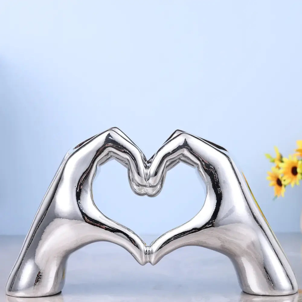 Shiny silver ceramic decorbites loving gesture heart sculpture of two hands forming a loving gesture heart for decor