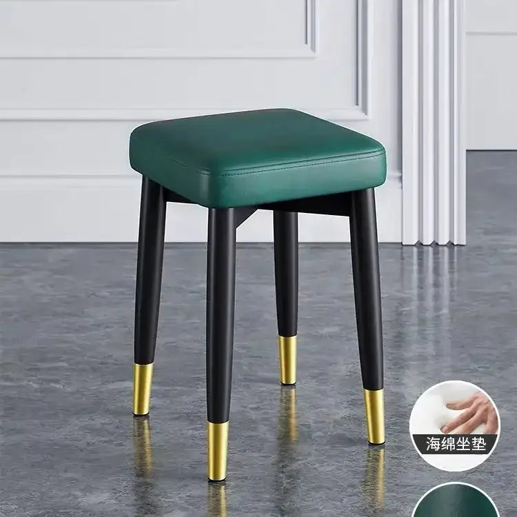 Emerald green upholstered decorbites low square stool bench with sleek black legs and gold tips for dining or kitchen use