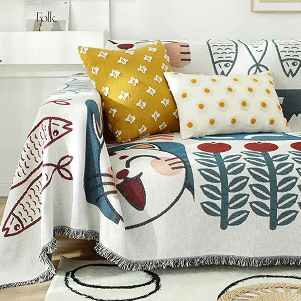 White knitted blanket with playful lucky cat, red and blue fish motifs, leaf patterns, and fringed edges by decorbites lucky cat