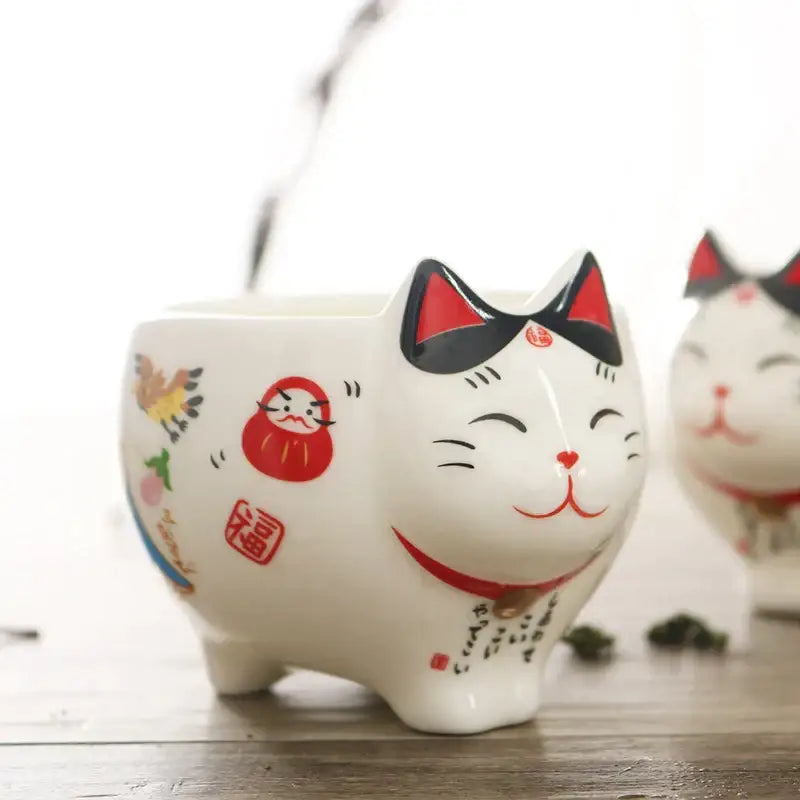 White ceramic decorbites lucky cat porcelain tea set with red accents and colorful japanese lucky motifs including daruma doll