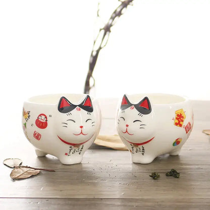 White ceramic decorbites lucky cat tea set featuring smiling maneki neko porcelain planters with red and black details