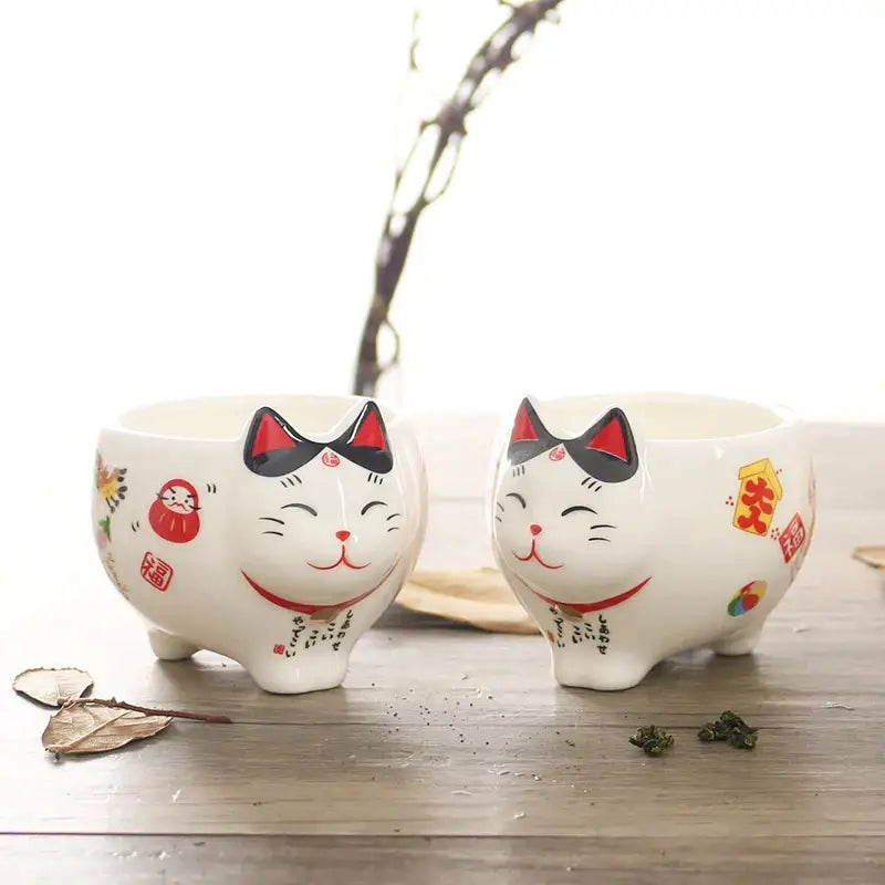 White ceramic decorbites lucky cat tea set featuring smiling maneki neko porcelain planters with red and black details