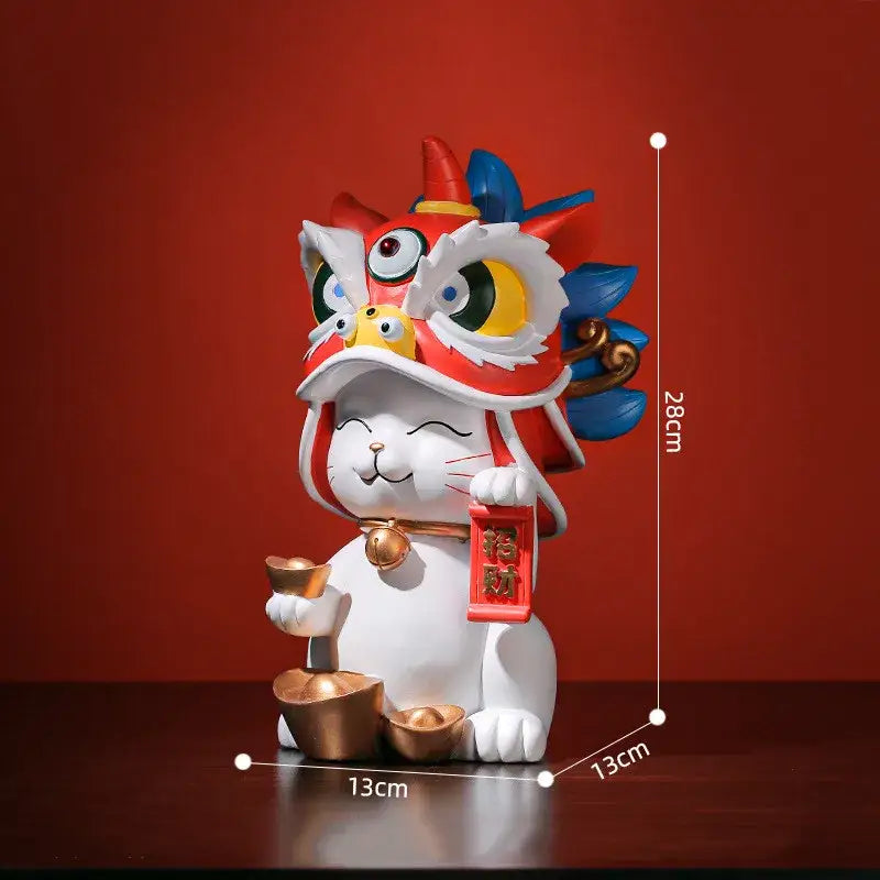 A white ceramic DecorBites Lucky Cat figurine wearing a colorful lion dance mask holding a red scroll and golden ingots