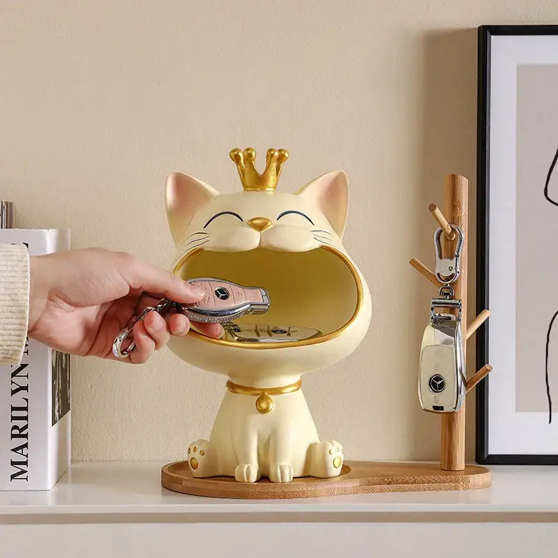 Cream-colored ceramic lucky cat sculpture with gold crown and collar designed as key holder by DecorBites™