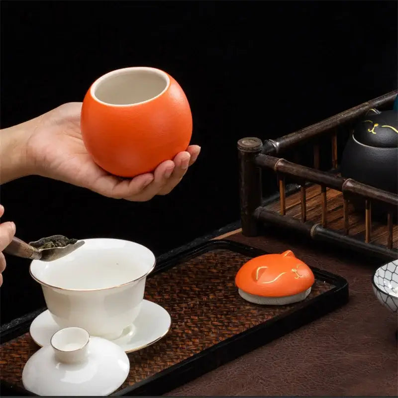 Orange ceramic tea storage jar with glossy finish and subtle gold rim detailing for tea and candy storage