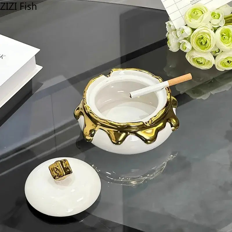 White ceramic ashtray with gold drip detailing and lid featuring golden emblem for DecorBites lucky ceramic ashtray
