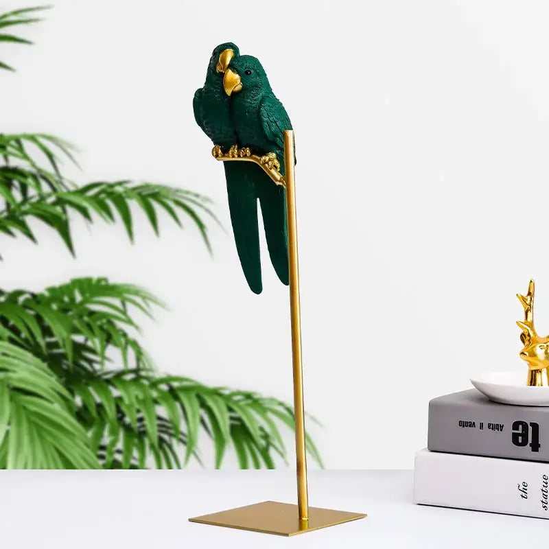 Green parrot resin ornament with gold beak and feet perched on a slender gold stand decorbites lucky parrot