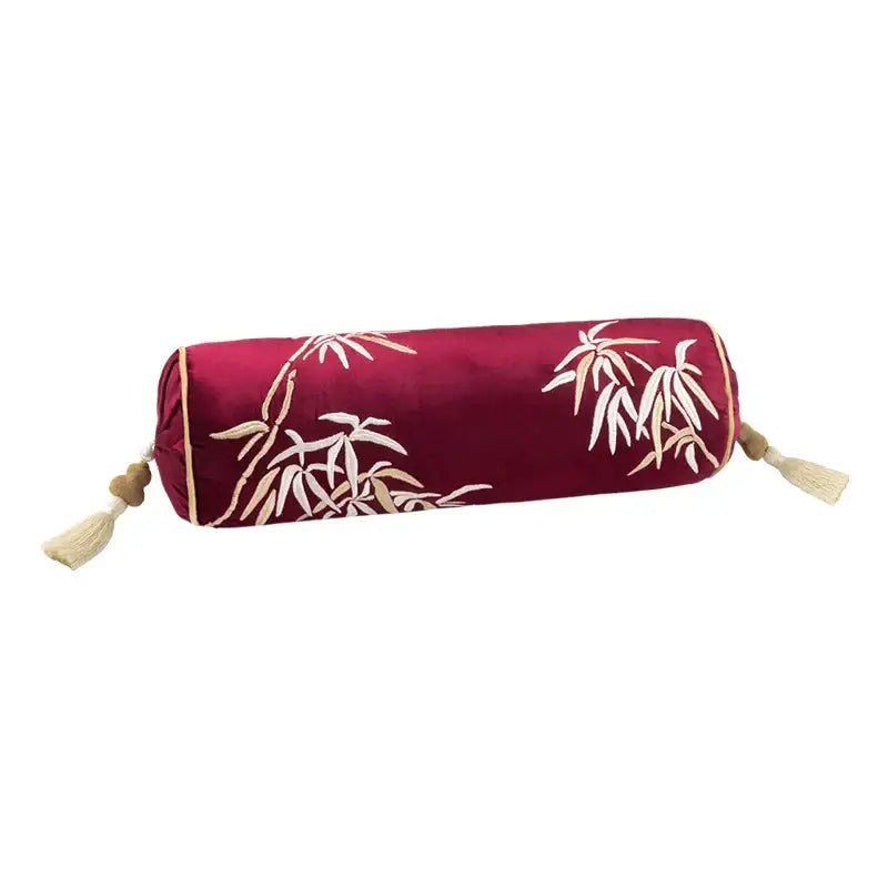 A plush deep red silk velvet cylindrical pillow with white beige bamboo embroidery and tassels by DecorBites Lucky Rabbit pine forests collection