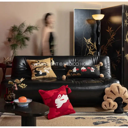 Black leather sofa with decorbites lucky rabbit embroidered throw pillows in silk velvet featuring pine forests design