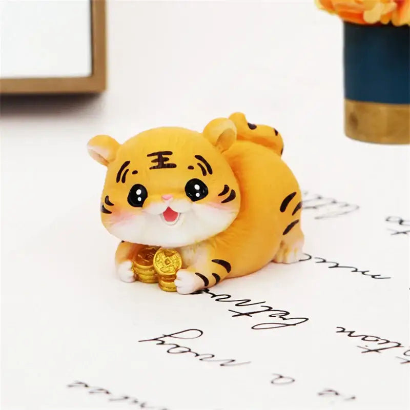 Cute yellow lucky tiger figurine with black stripes smiling and holding golden coins for new year home decor