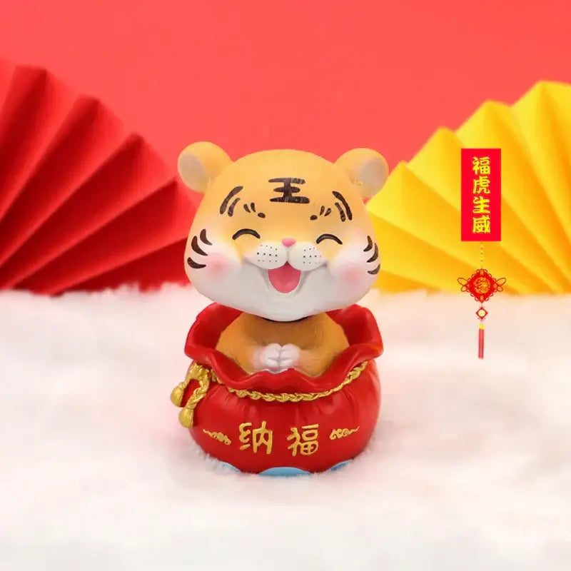 Decorbites™ lucky tiger figurine in orange with black whiskers sitting in a red money pouch for new year fortune