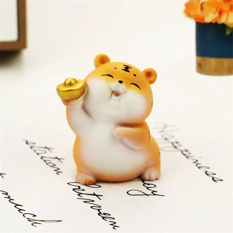 Cute orange and white ceramic lucky tiger figurine holding a golden ingot for new year fortune home decor