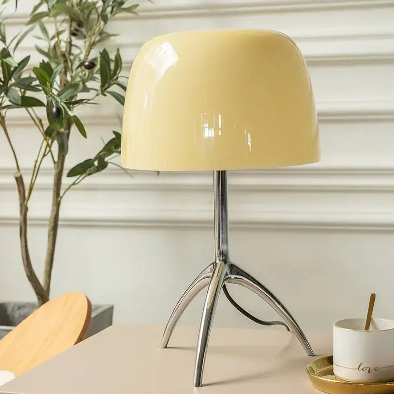 Cream-colored glossy decorbites lumiere glass table lamp with sleek chrome tripod base for bedroom and living room use