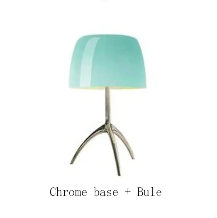 A sleek decorbites lumiere table lamp with a glossy teal glass shade and polished chrome tripod base for bedroom use