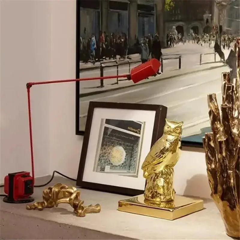 Gold owl figurine with polished metallic finish and detailed feathering on square base beside decorbites lumina long arm floor lamp
