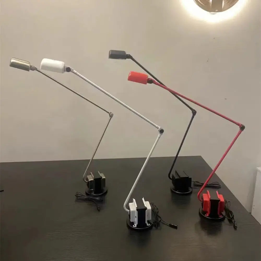 Three decorbites lumina floor lamps with long adjustable metal arms and colored heads in white black and red for study use